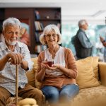 Pareja de ancianos mirando alegremente a la cámara