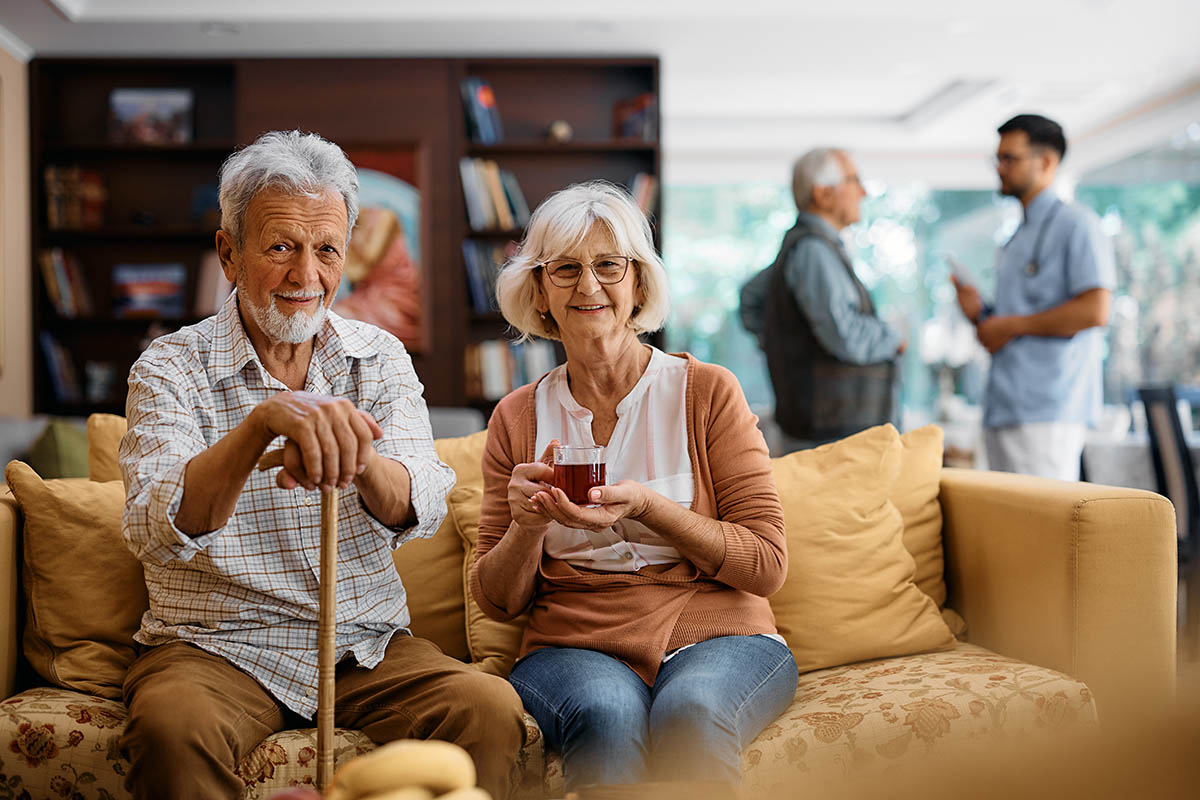 Pareja de ancianos mirando alegremente a la cámara