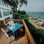 Balcón frente al mar con una pequeña mesita