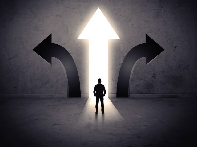 Silueta de persona ante tres flechas direccionales iluminadas que representan decisión de inversión