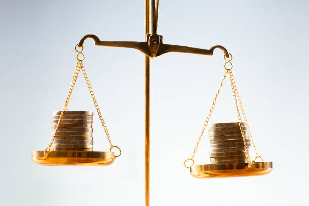 Balanza dorada con pilas de monedas equilibradas simbolizando comparativa de precios de vivienda