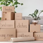 Cajas de mudanza clasificadas por nombres, apiladas en un salón