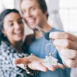 Pareja sosteniendo las llaves de una nueva casa