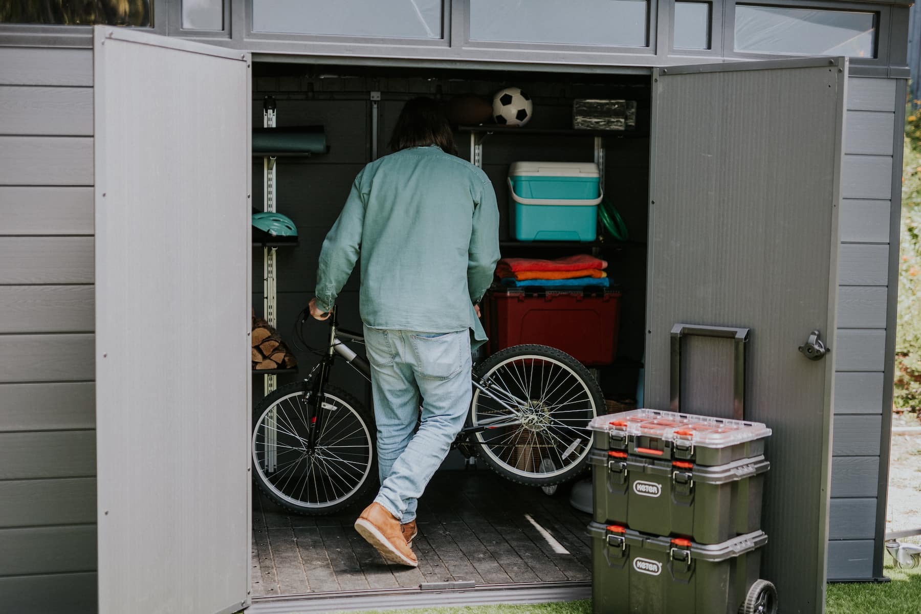 persona guardando bicicleta en un trastero